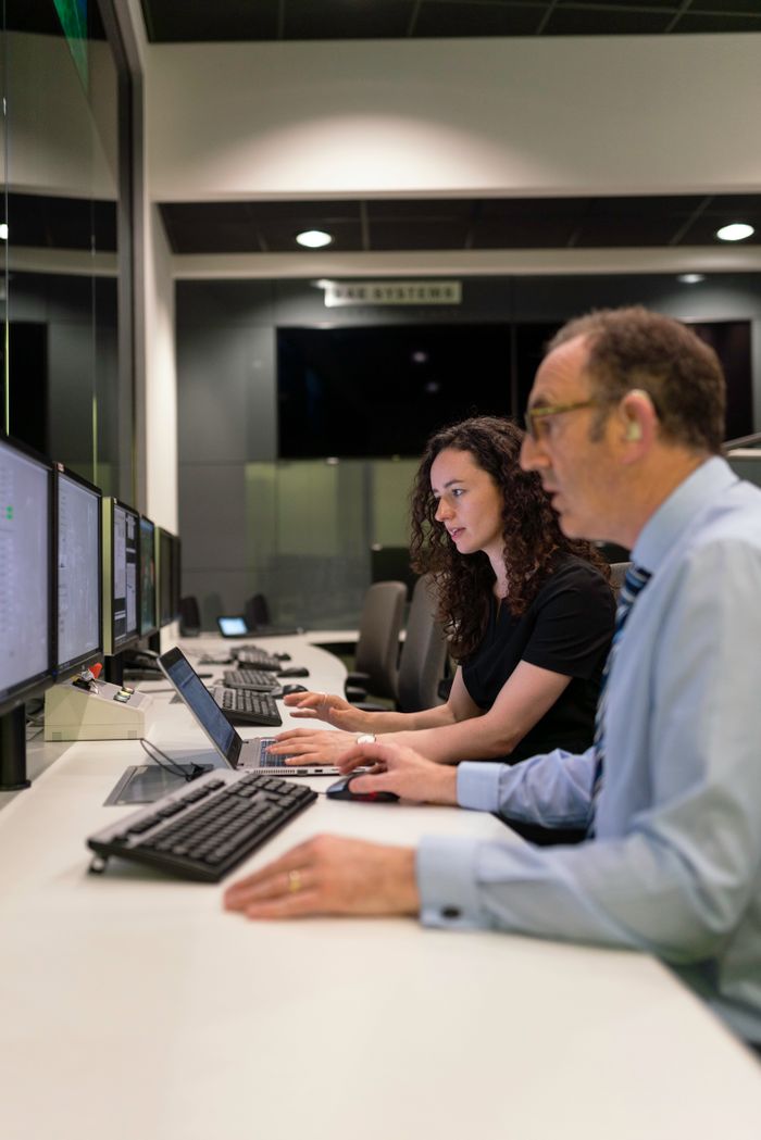 Engineers working together in a modern control room focused on simulation and testing.